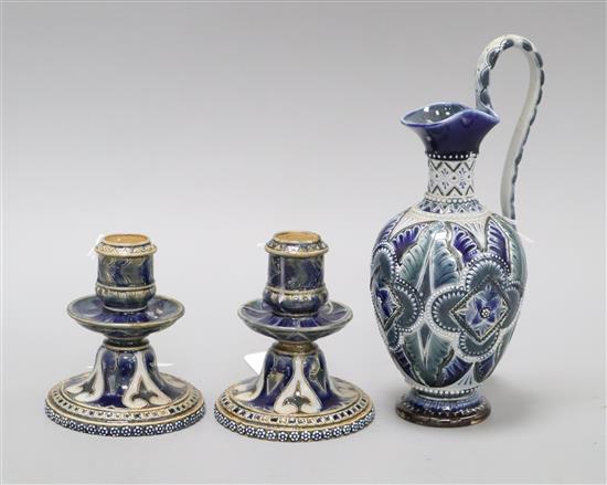 A Doulton Lambeth ewer, dated 1879, signed BE and RR? and a similar pair of squat candlesticks, dated 1877 by Elizabeth A. Sayers and A